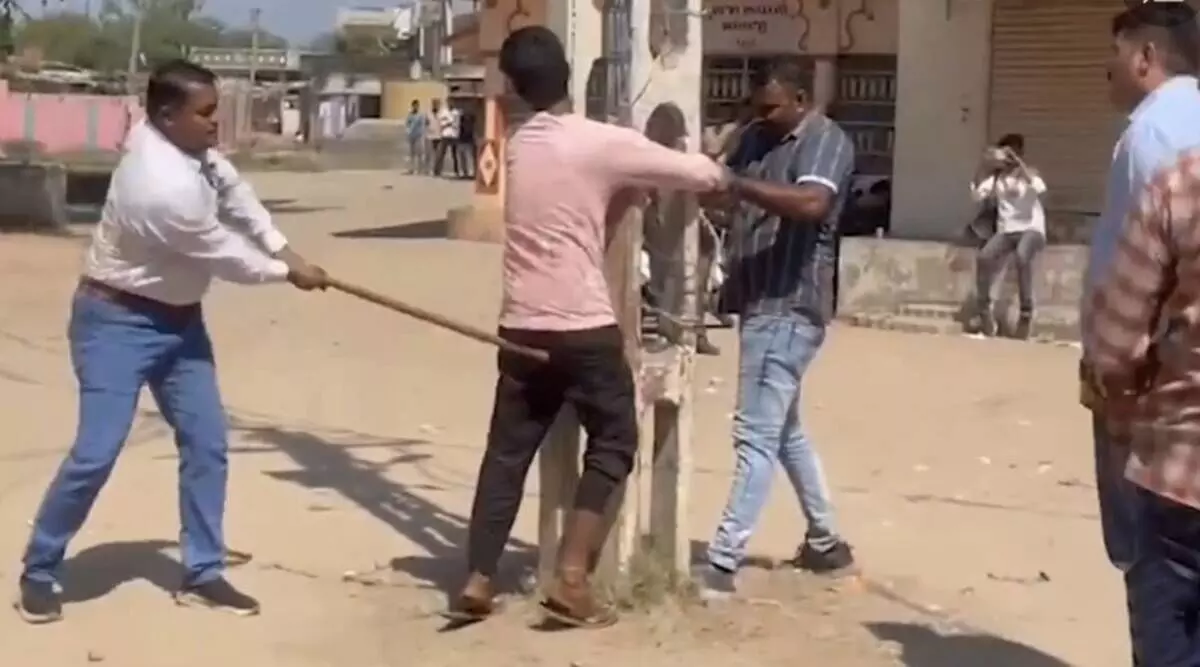 Police thrash men before a cheering public alleging rioting